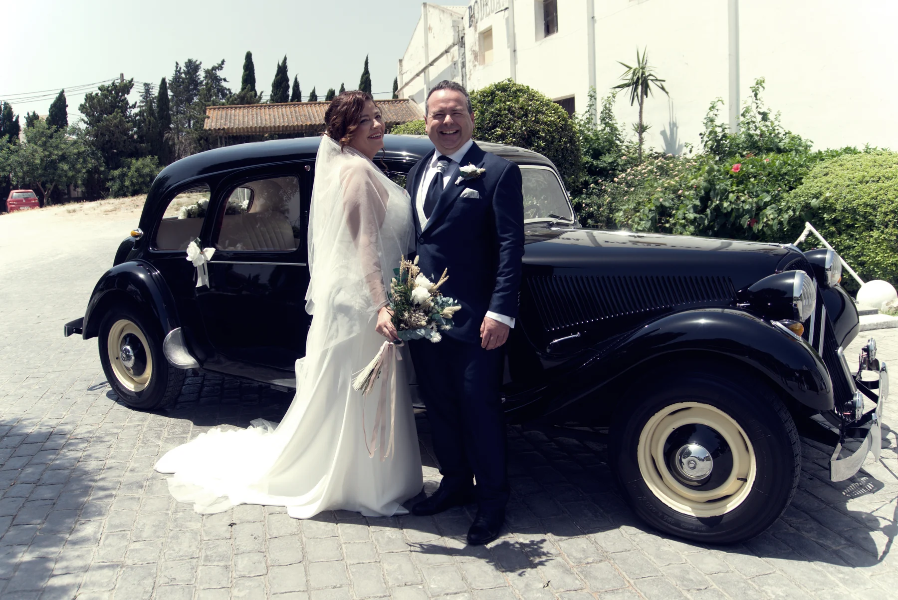 Pareja de recién casados junto a un coche clásico
