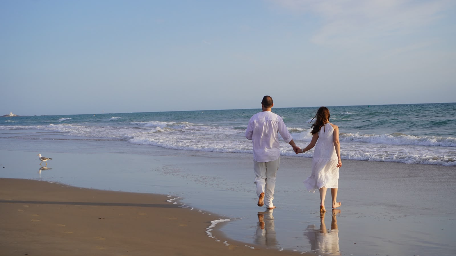Pareja caminando de la mano por la playa durante una sesion de preboda de TSD Eventos